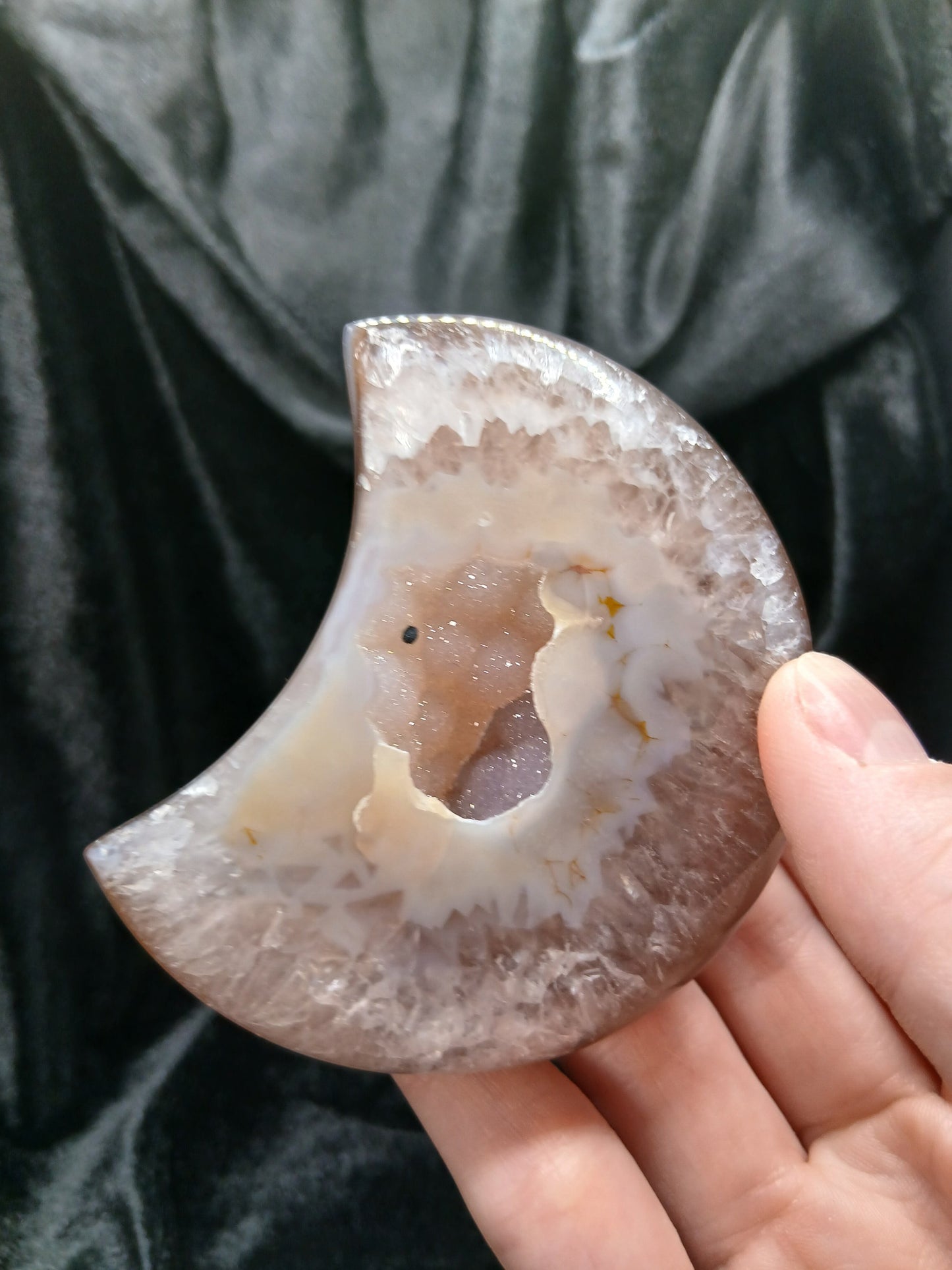 Fordite Haus: Crystals & Fordite taupe and white agate moon carving with a central druzy geode cave held in hand