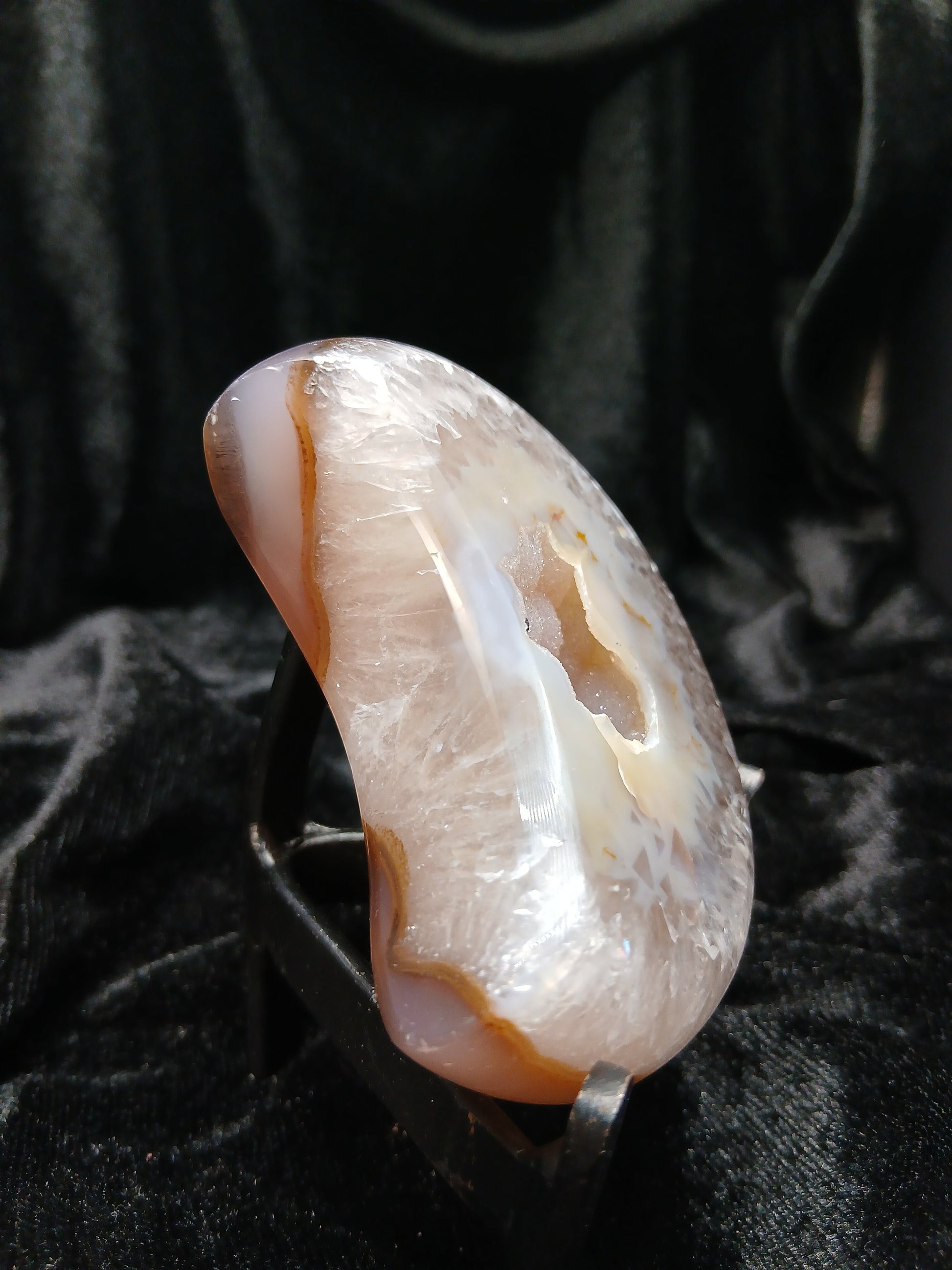 Fordite Haus: Crystals & Fordite Brazilian agate moon carving in taupe and white with a central druzy geode on a stand