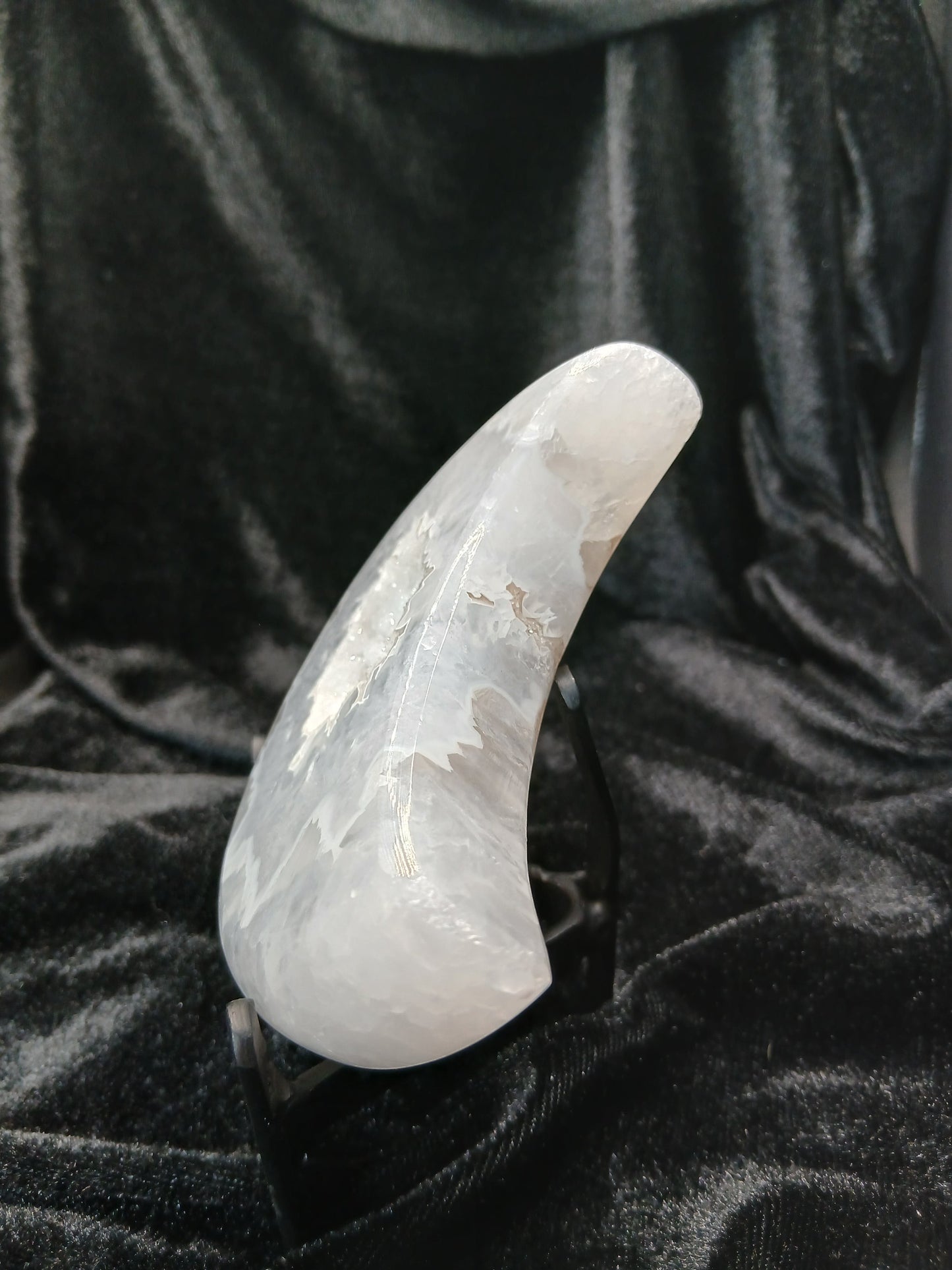 Fordite Haus: Crystals & Fordite agate moon carving with druzy texture on a black display stand