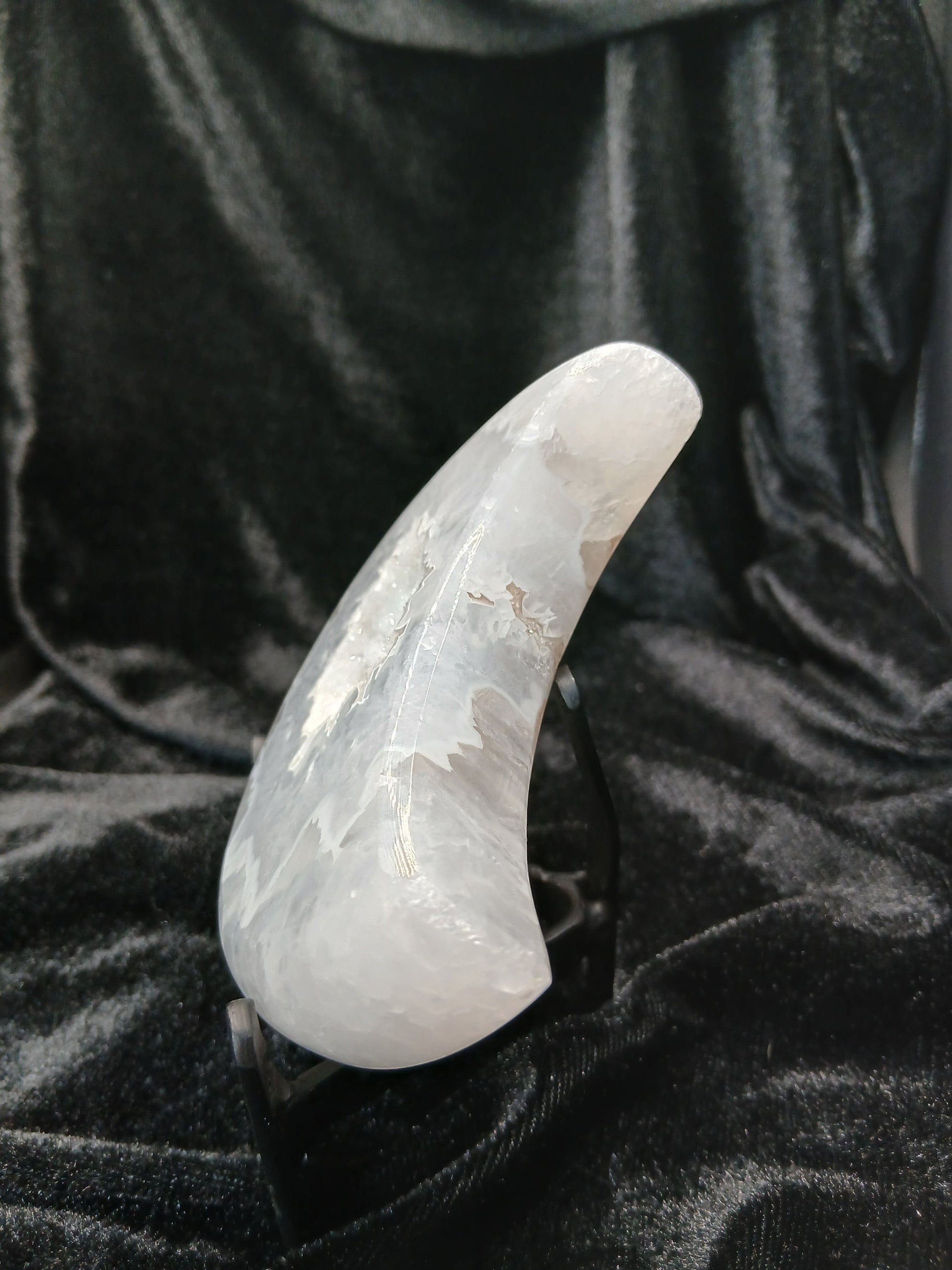 Fordite Haus: Crystals & Fordite agate moon carving with druzy texture on a black display stand