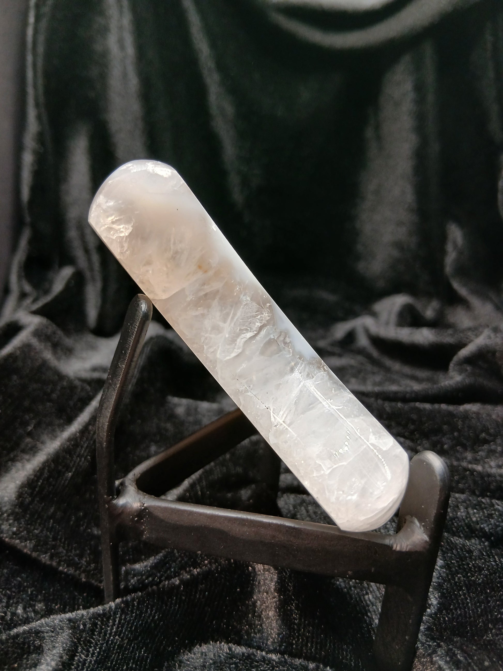 Fordite Haus: Crystals & Fordite agate moon carving with icy white and blue banding, polished finish, and display stand.