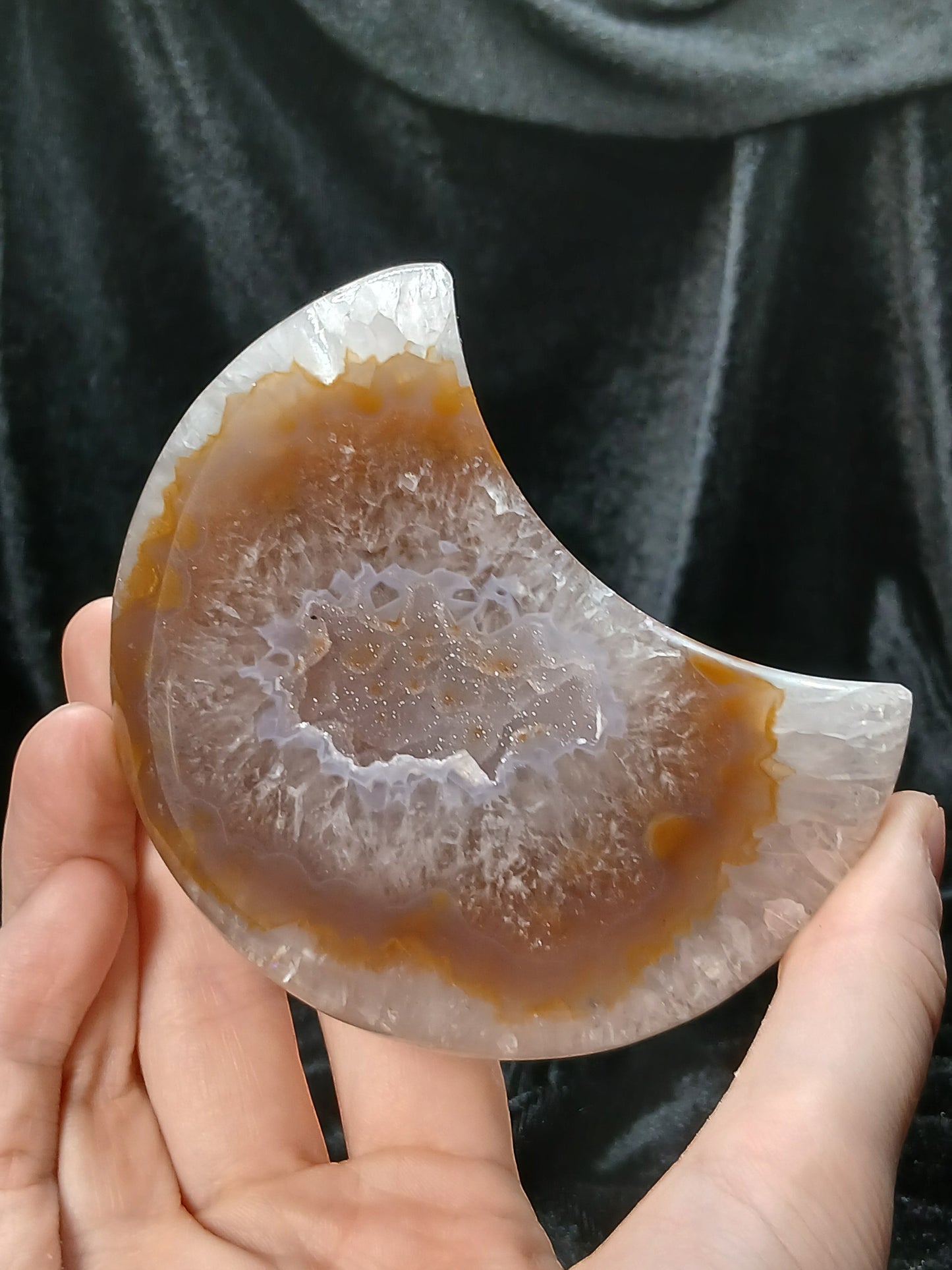 Fordite Haus: Crystals & Fordite agate moon carving with brown and translucent crystalline center held in hand