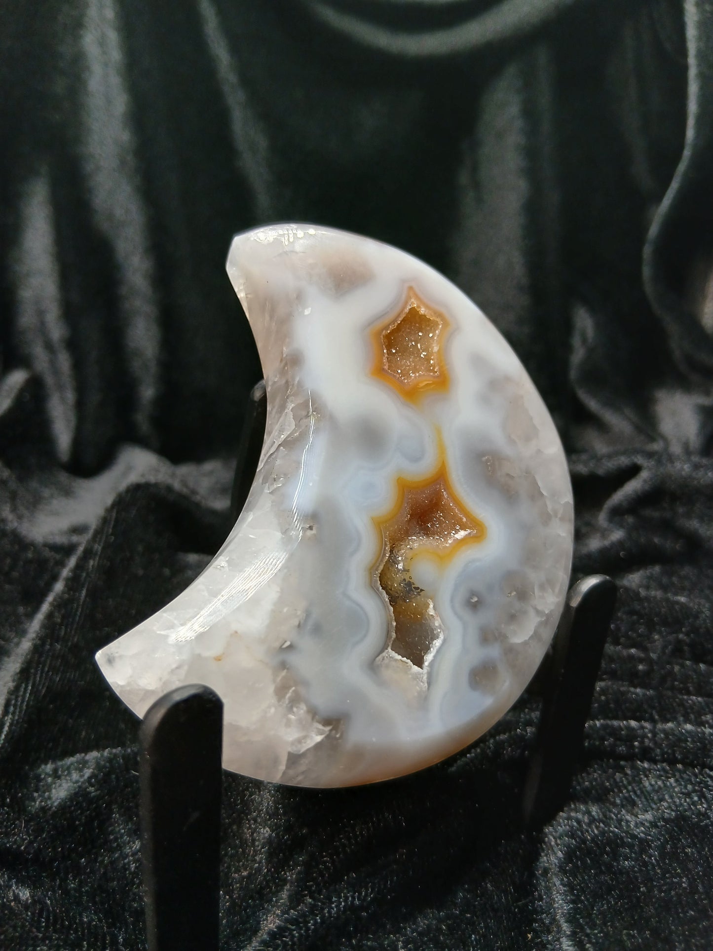 Fordite Haus: Crystals & Fordite agate moon carving with icy blue and white banding and golden druzy crystal caves.