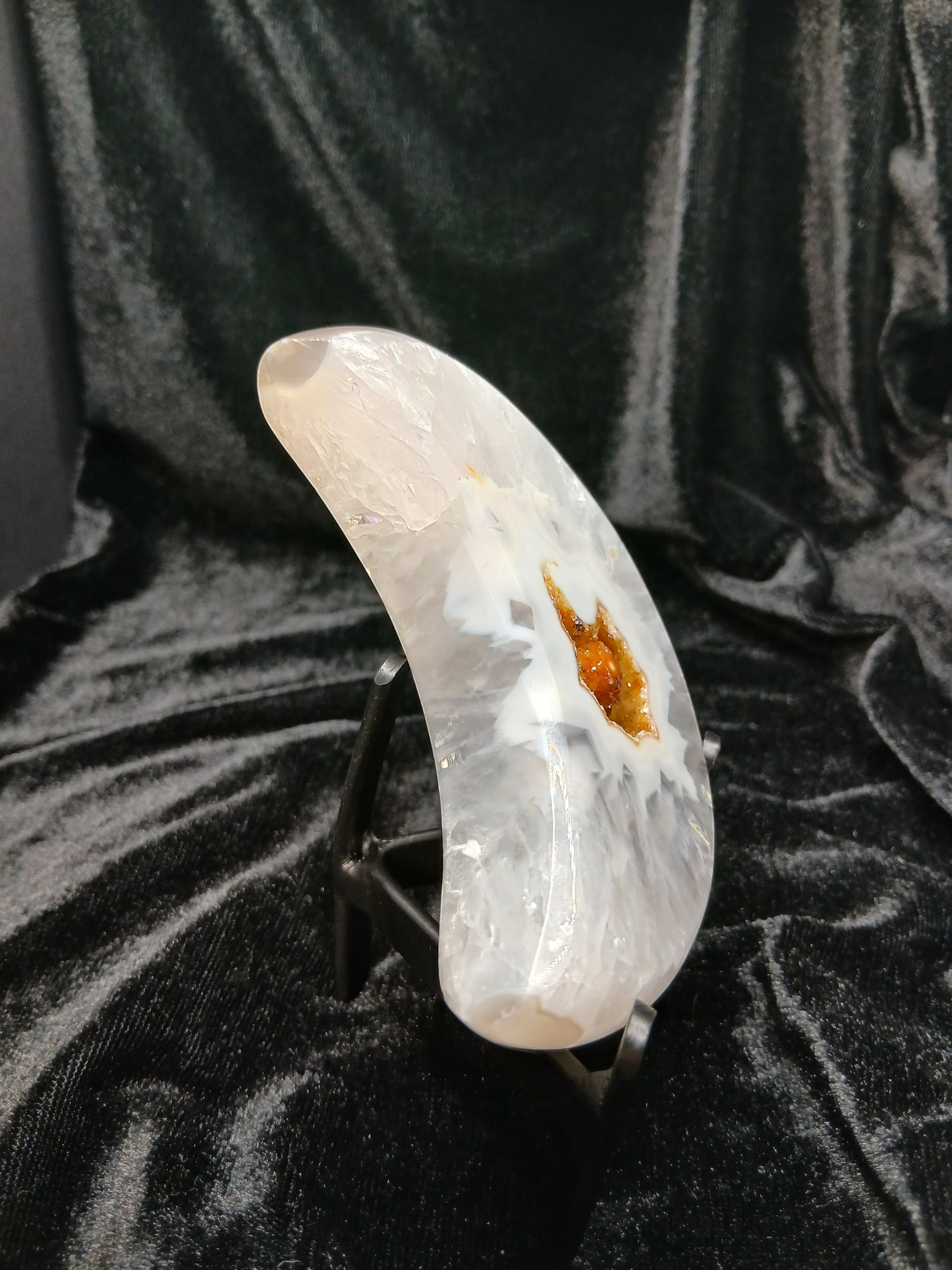 Fordite Haus: Crystals & Fordite agate moon carving with a central druzy geode pocket on a black display stand