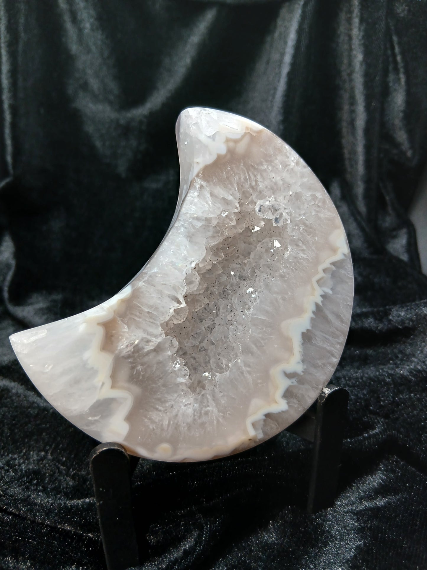 Fordite Haus: Crystals & Fordite agate moon carving with a sparkling druzy crystal center on a black display stand