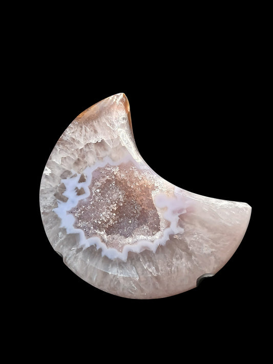 Fordite Haus: Crystals & Fordite 3.5-inch agate moon carving with a sparkling druzy center on a black display stand.