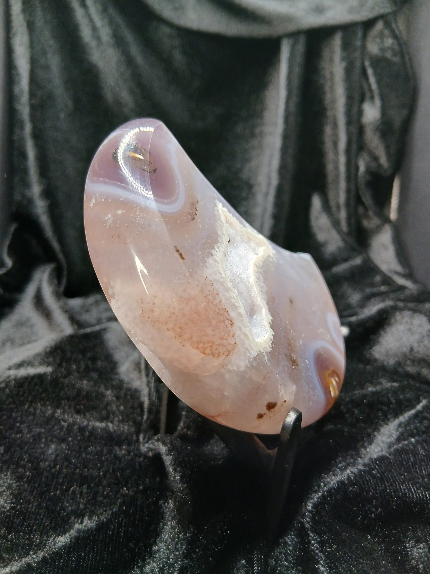 Fordite Haus: Crystals & Fordite polished agate moon carving with natural banding on a black display stand.