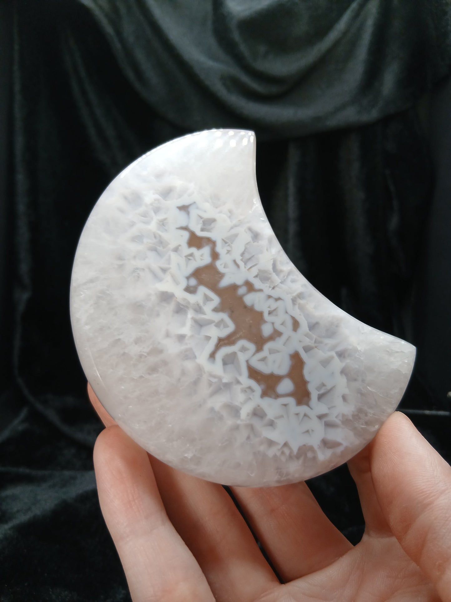 Fordite Haus: Crystals & Fordite agate moon carving with white crystalline patterns held in a hand