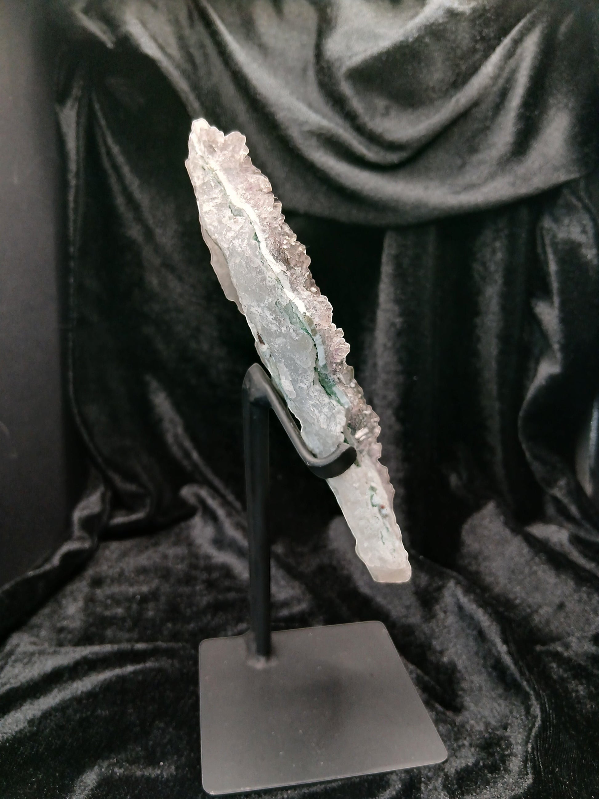 Fordite Haus: Crystals & Fordite green chalcedony and lavender amethyst flower specimen on a black metal display stand.
