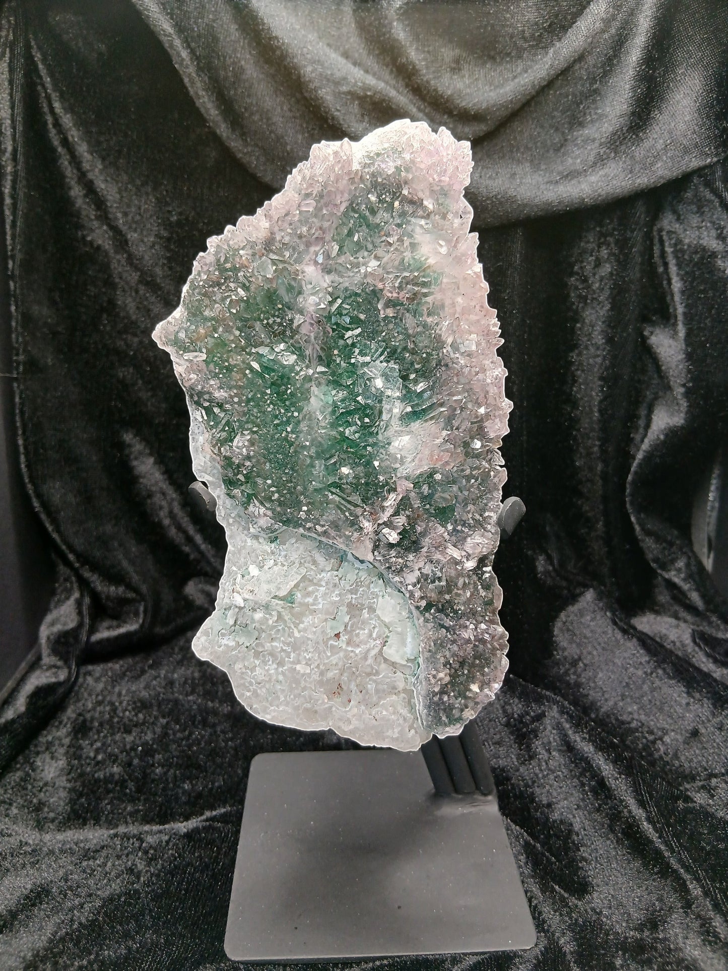 Fordite Haus: Crystals & Fordite green chalcedony and lavender amethyst flower crystal specimen on a black metal stand.