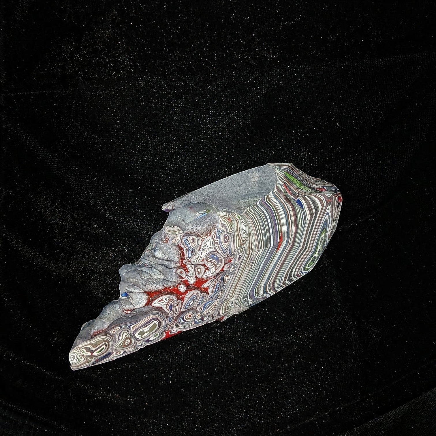 Fordite Haus: Crystals & Fordite 84g Jeepite slab with multi-colored enamel paint layers on a black background.