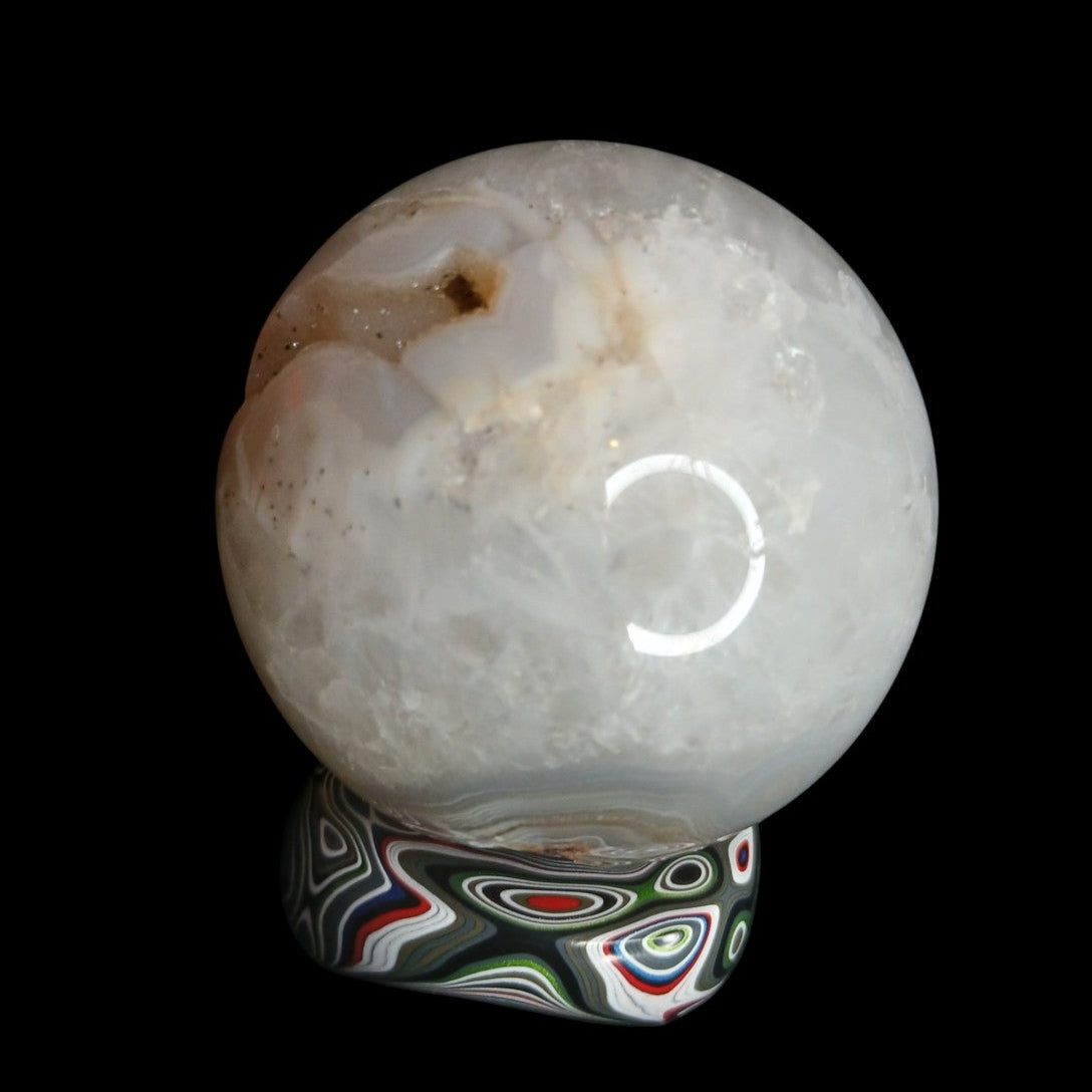 Fordite Haus: Crystals & Fordite Jeepite sphere stand featuring colorful automotive paint layers holding a crystal