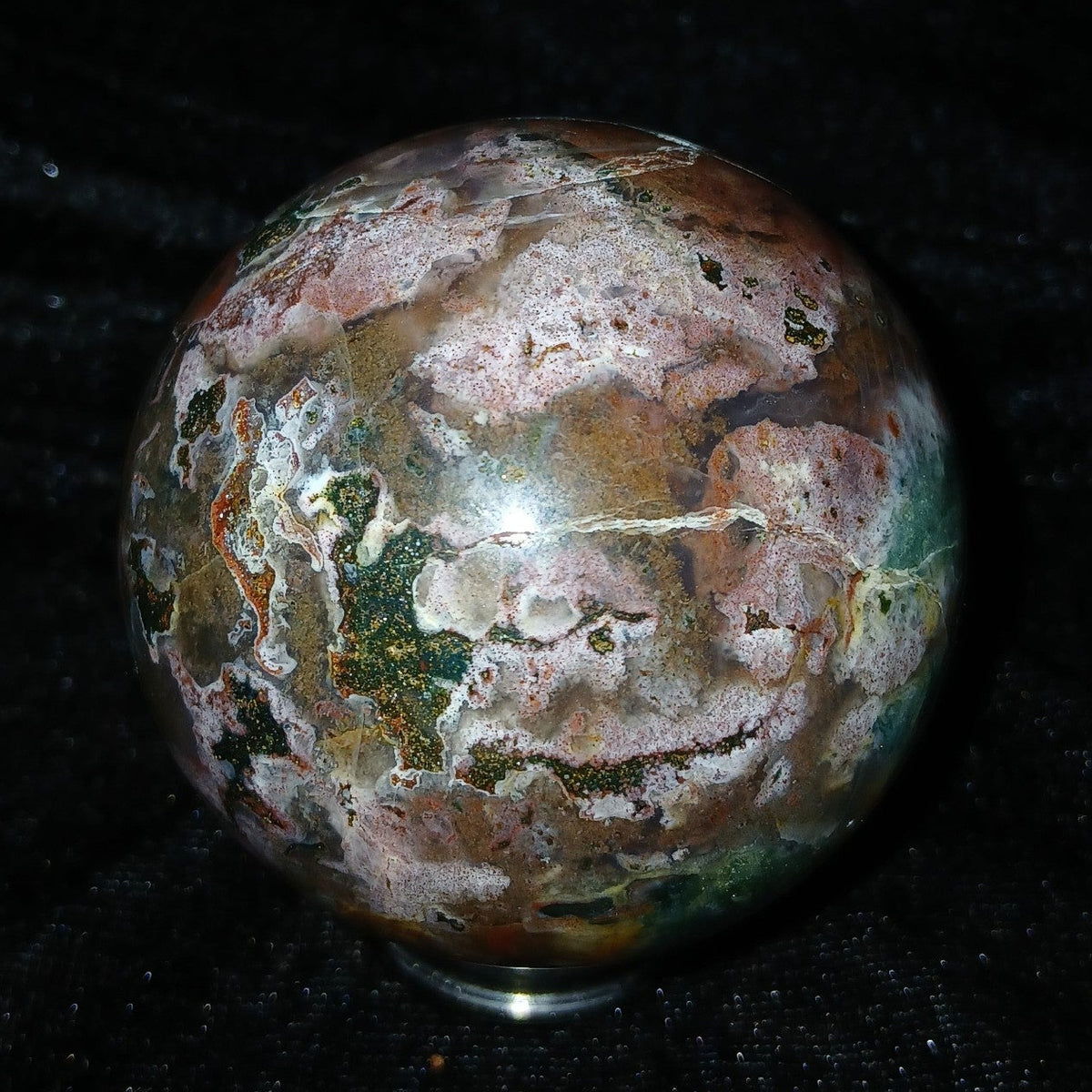 Fordite Haus: Crystals & Fordite 57.3mm polished Ocean Jasper sphere with green, red, pink, and white patterns.