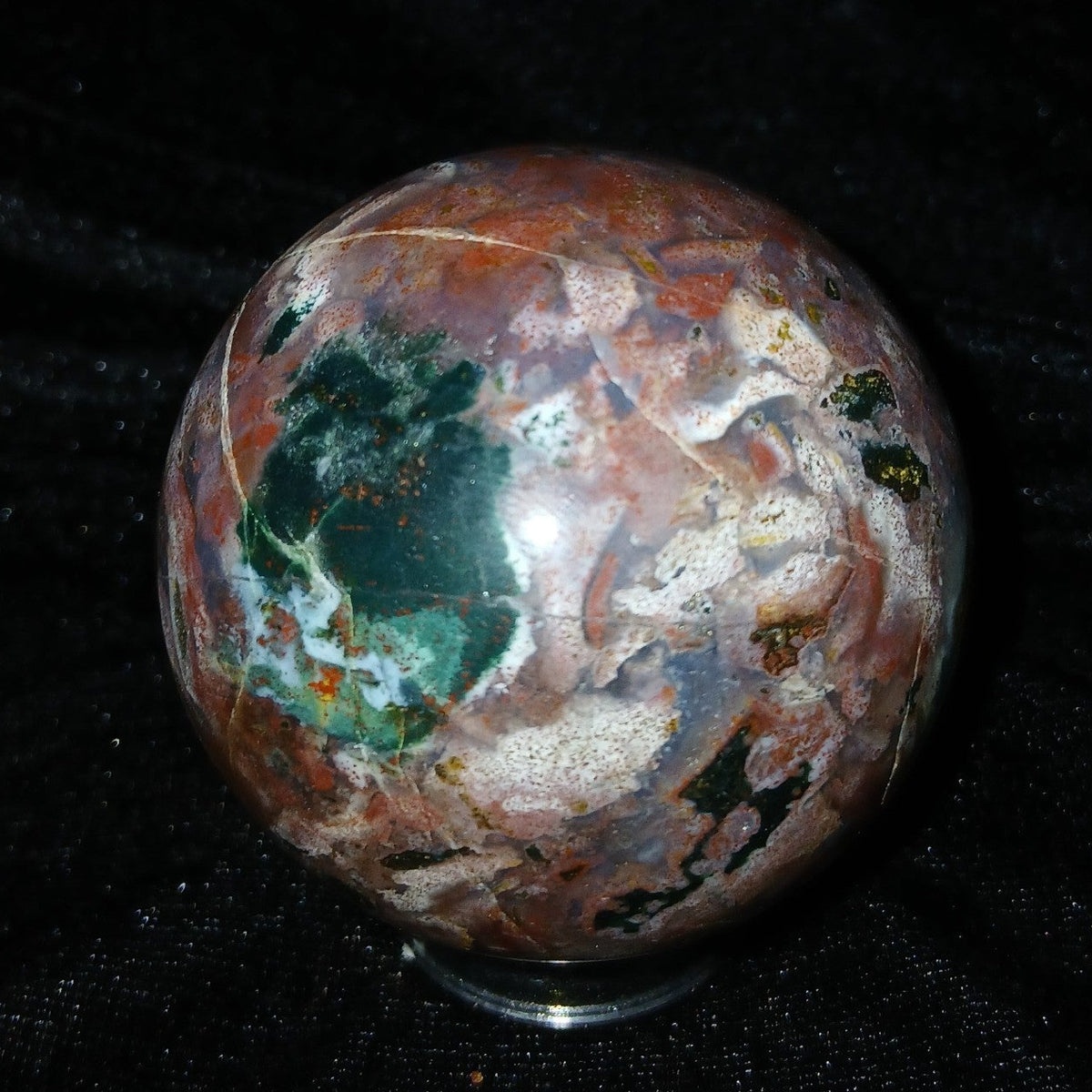 Fordite Haus: Crystals & Fordite 57.4mm Ocean Jasper sphere from Madagascar with green, red, and white patterns.