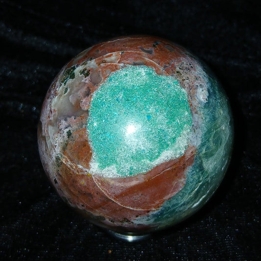 Fordite Haus: Crystals & Fordite 57.3mm polished Ocean Jasper sphere with green, red, and white patterns.