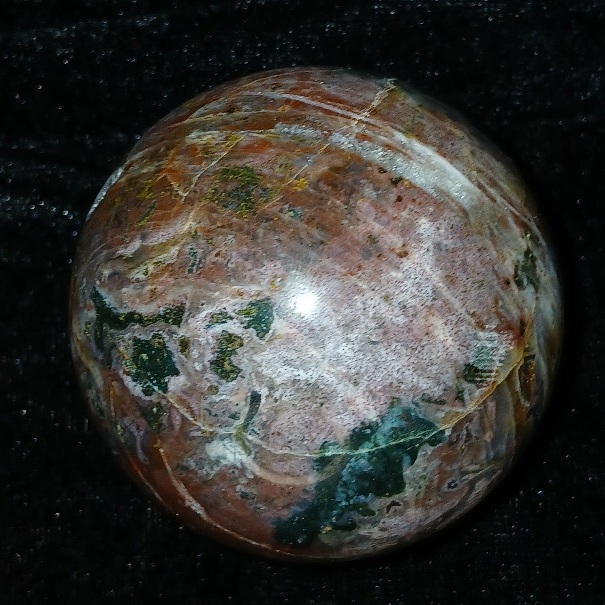 Fordite Haus: Crystals & Fordite 61mm Ocean Jasper sphere from Madagascar with earthy red, green, and white patterns.