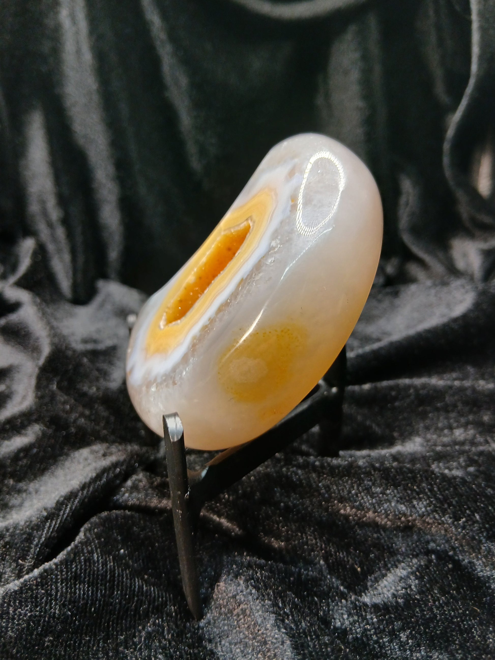 Fordite Haus: Crystals & Fordite polished peachy agate crescent moon carving with natural banding on a display stand.
