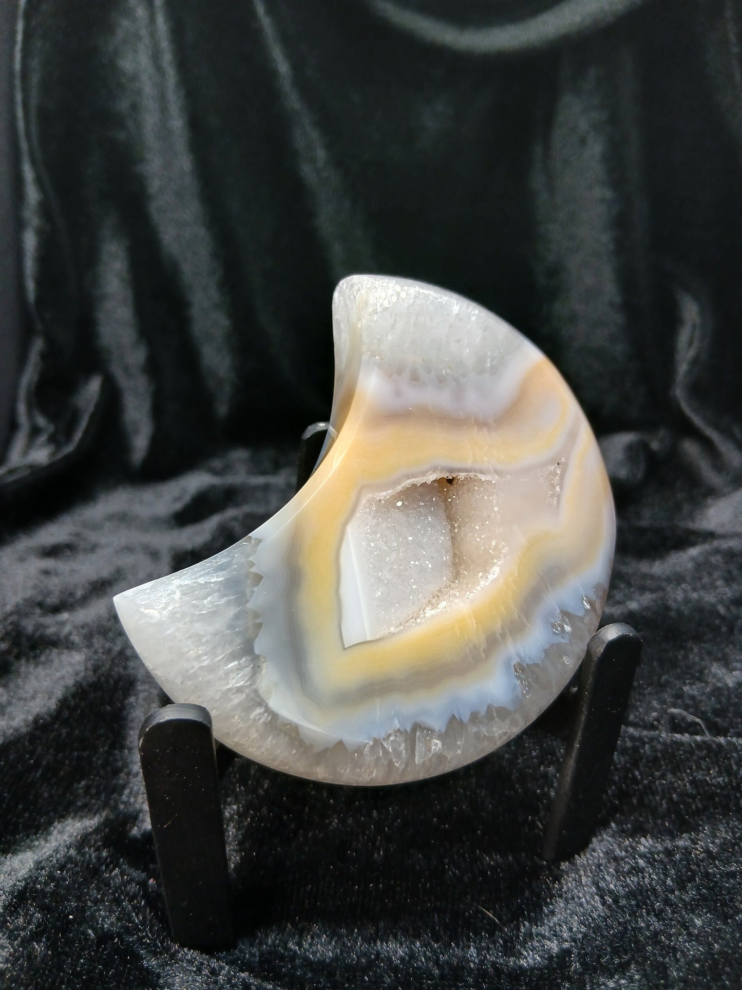 Fordite Haus: Crystals & Fordite peachy agate crescent moon carving with natural banding and a central druzy geode.