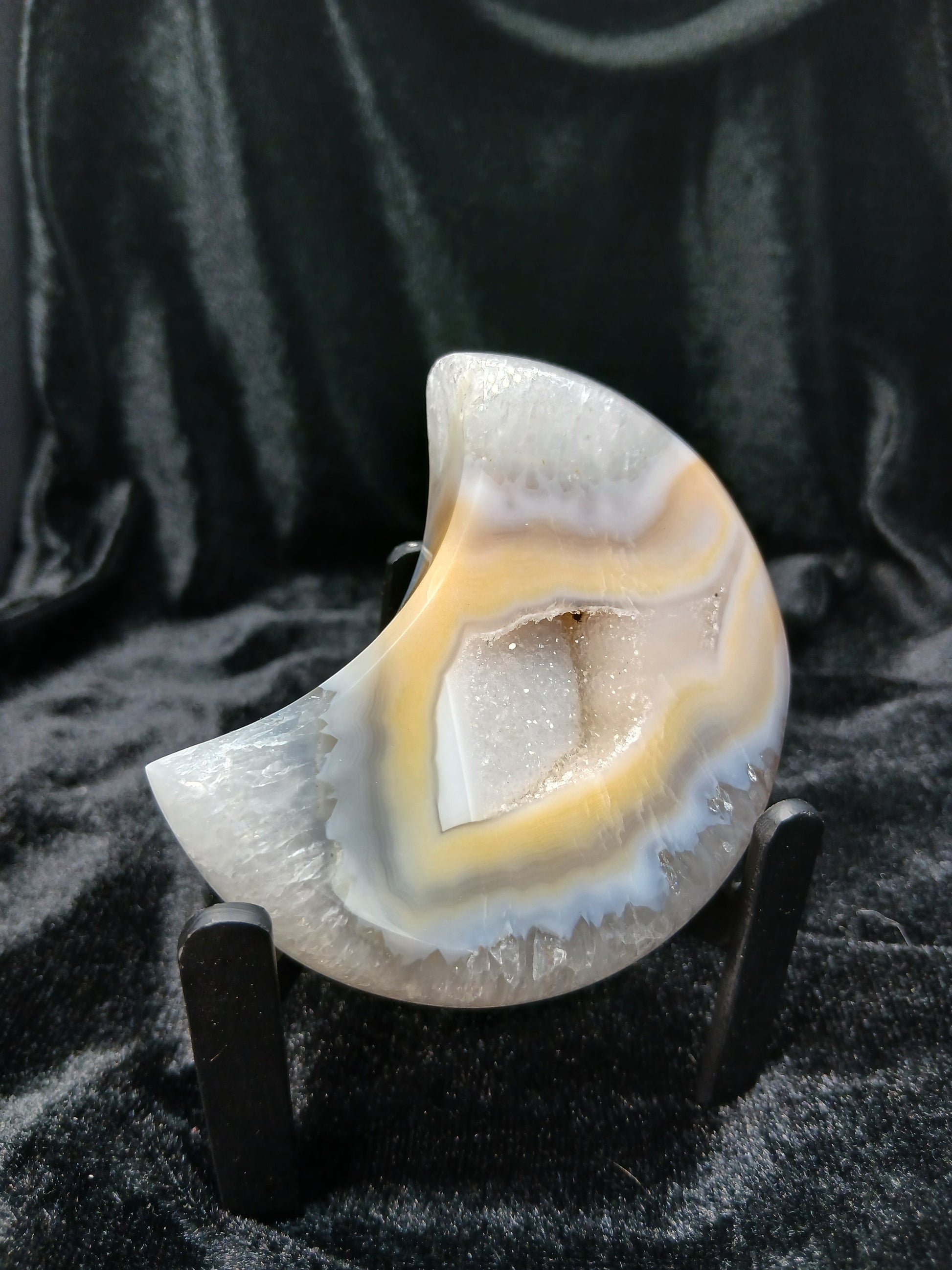 Fordite Haus: Crystals & Fordite peachy agate crescent moon carving with natural banding and a central druzy geode.
