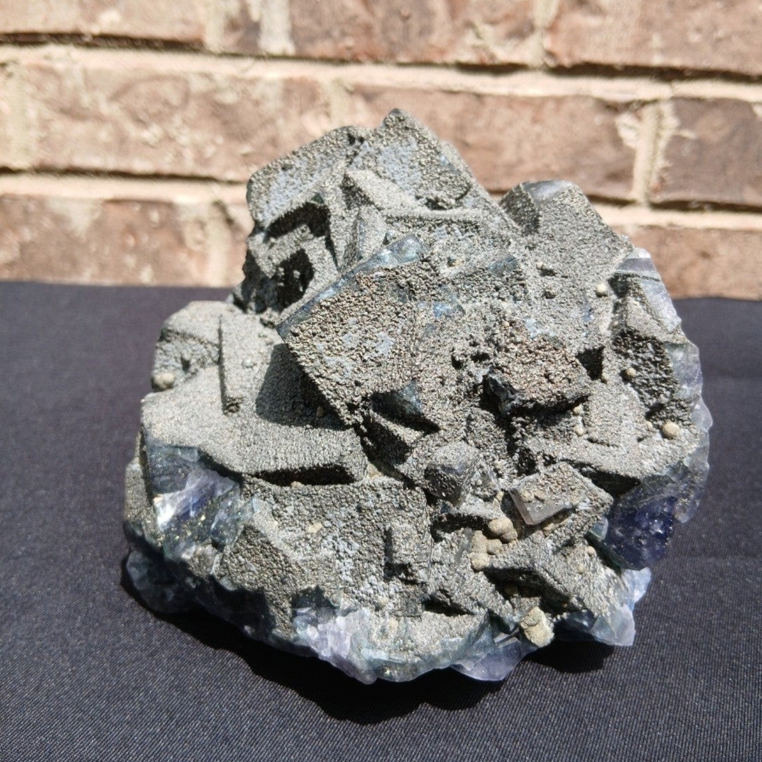 Fordite Haus: Crystals & Fordite 6.9lb cubic fluorite mineral specimen with green and purple hues and pyrite dusting.
