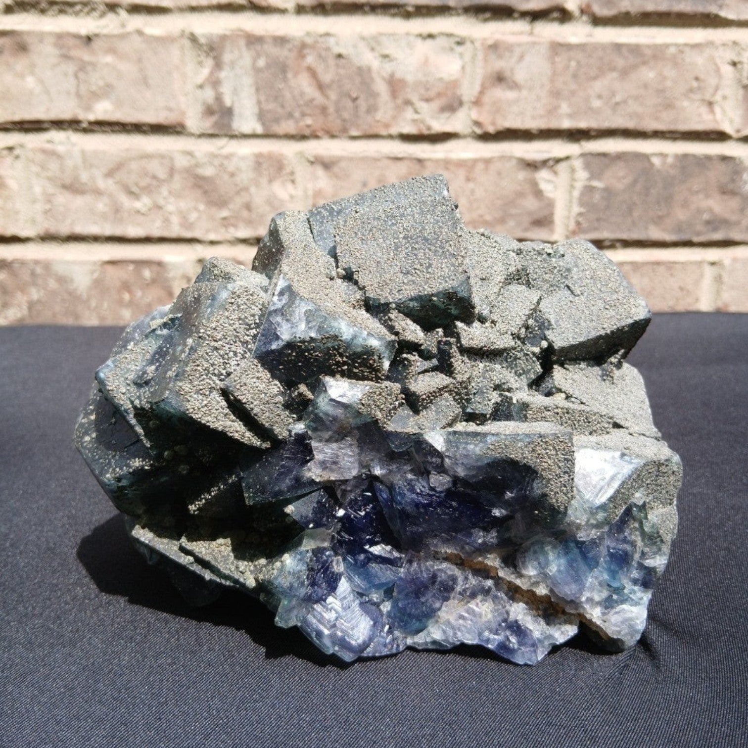 Fordite Haus: Crystals & Fordite 6.9lb cubic fluorite mineral specimen with green and blue tones and pyrite dusting.